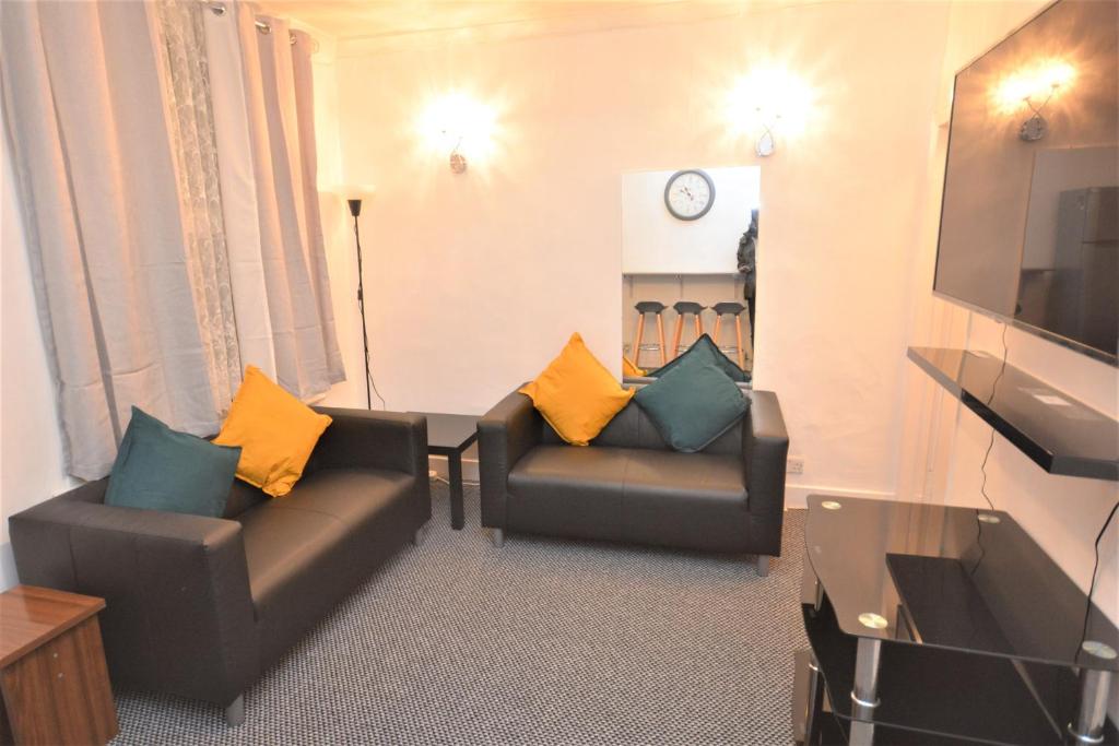 a living room with two couches and a television at Lovely 3 Bedroom House near Barking Station in Barking
