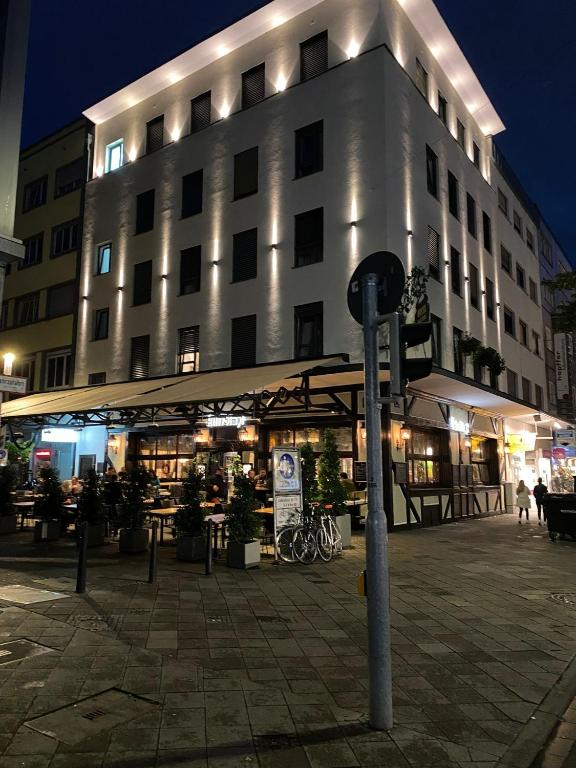 een groot gebouw met een paraplu ervoor bij Hotel-an-den-Planken in Mannheim