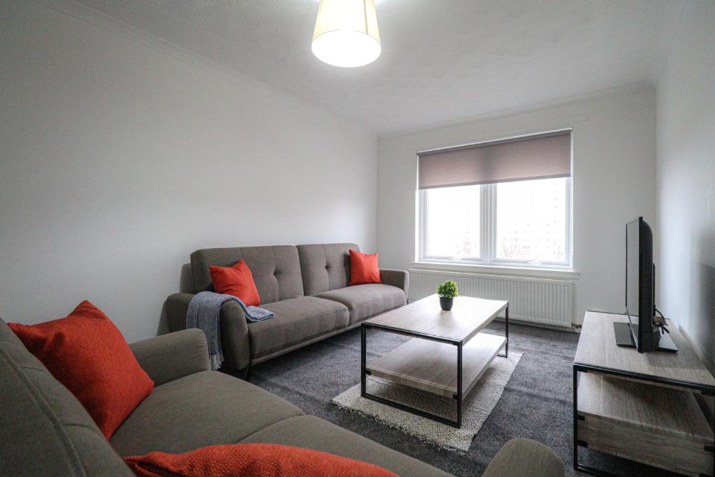 a living room with a couch and a tv at Jackson Apartment in Coatbridge