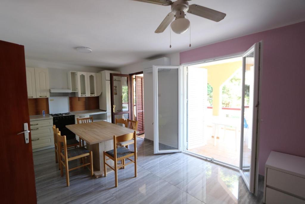 a kitchen and dining room with a table and a ceiling fan at Antodo Alen in Novalja
