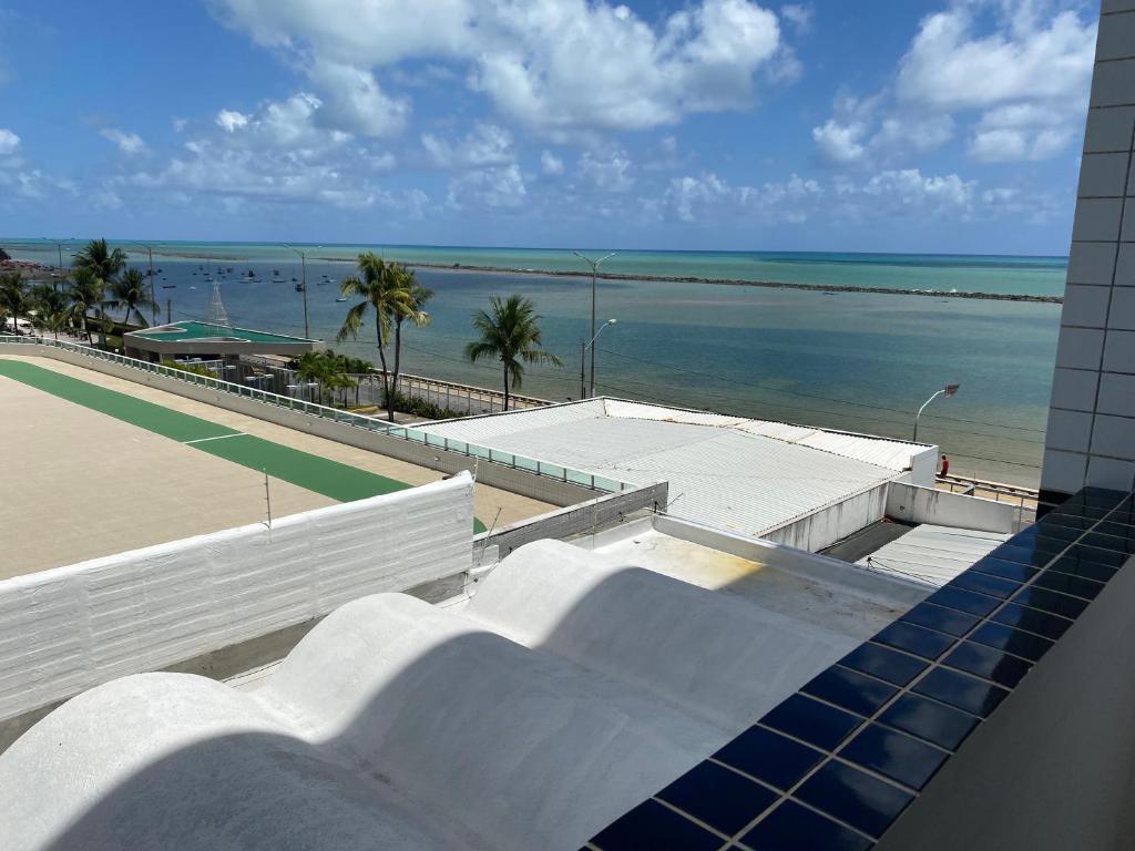 - une vue sur un court de tennis et l'océan depuis un bâtiment dans l'établissement Flat beira mar, Olinda 4 Rodas 315, à Olinda