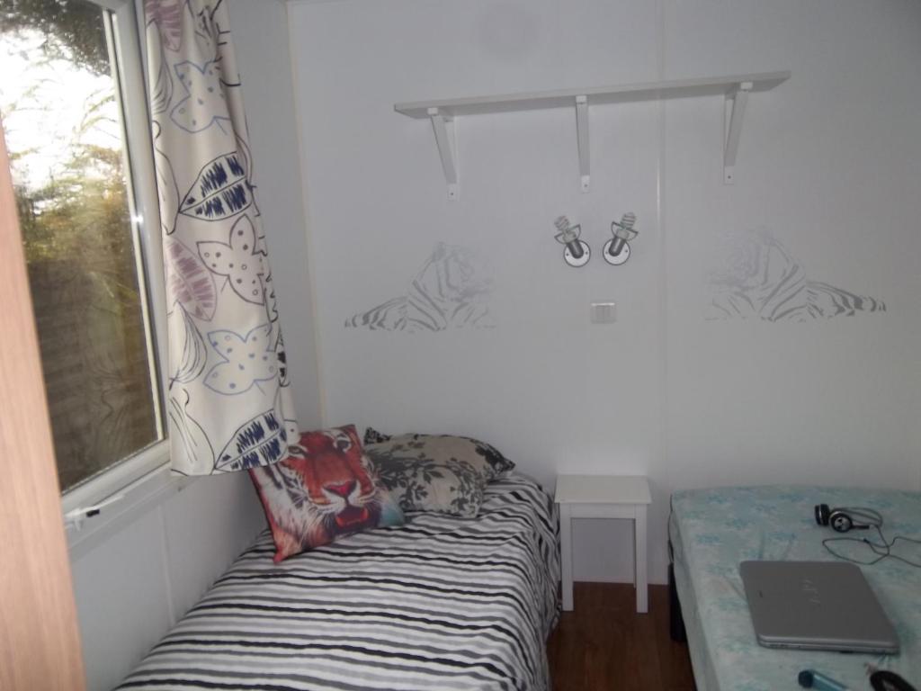 A bed or beds in a room at Mobil home - Clim, TV - Camping &#39;4 &eacute;toiles&#39; - Vic-la-Gardiole - 008