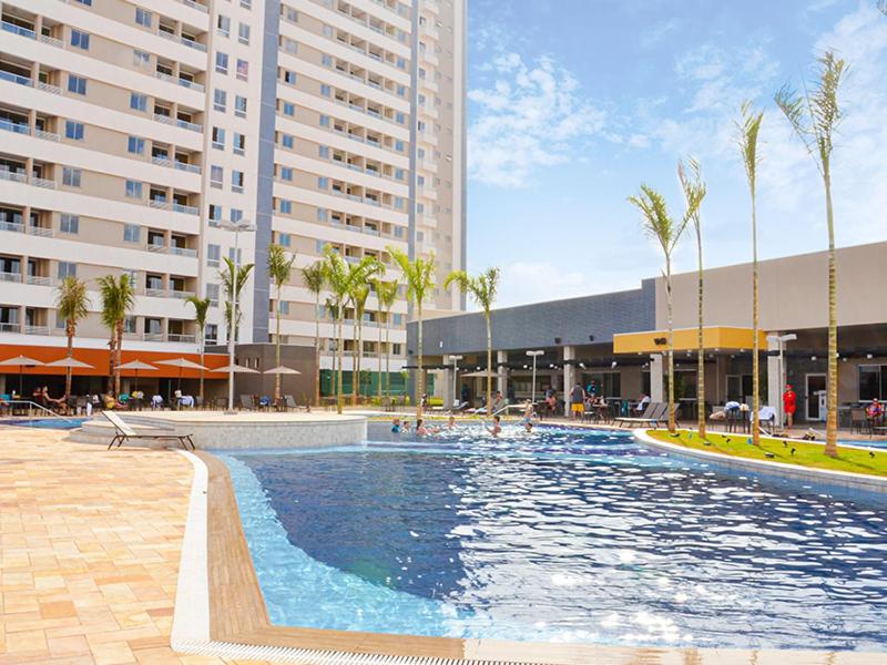 een groot zwembad met palmbomen en gebouwen bij Solar das Aguas Park in Olímpia