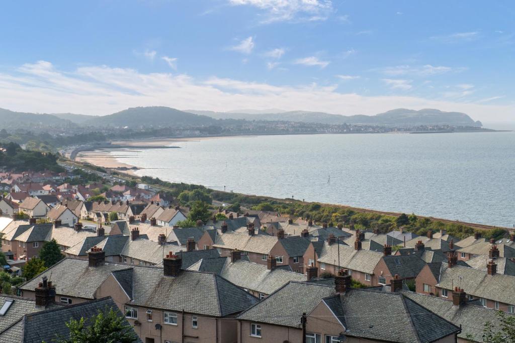 a view of a town with houses and the water at Windy Ridge Terrace with beautiful sea views, North Wales Coast in Old Colwyn