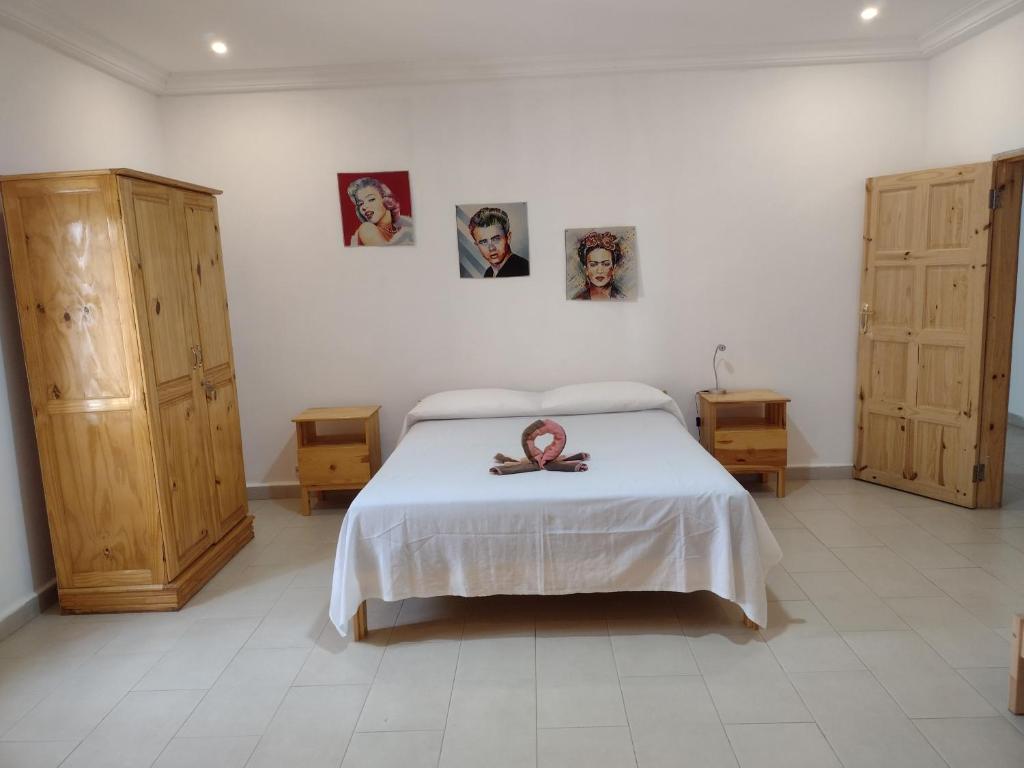 1 dormitorio con 1 cama y algunas fotos en la pared en Unique Owl Apartments en Sanyang