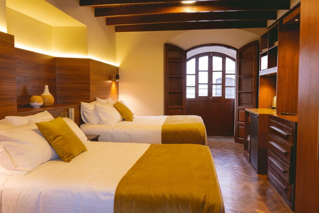 蘇克雷的住宿－San Juan Suites，酒店客房设有两张床和窗户。