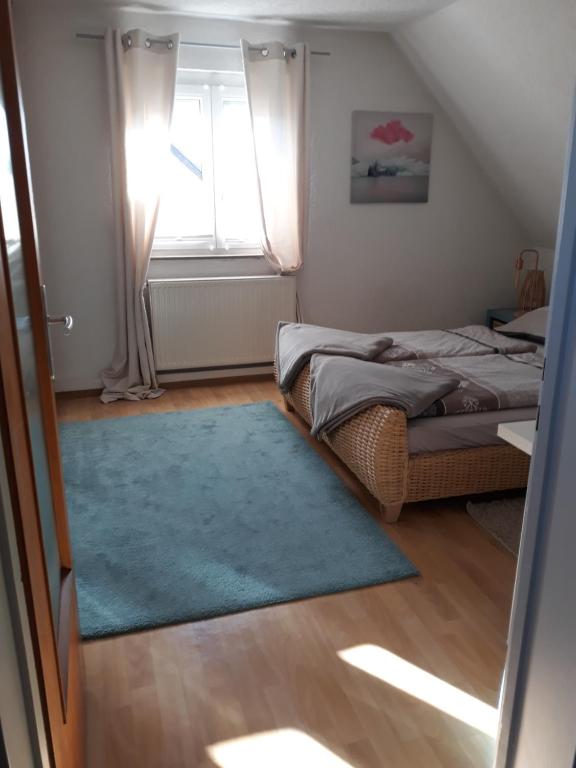 Habitación pequeña con 2 camas y alfombra azul en Kandelblick, en Teningen