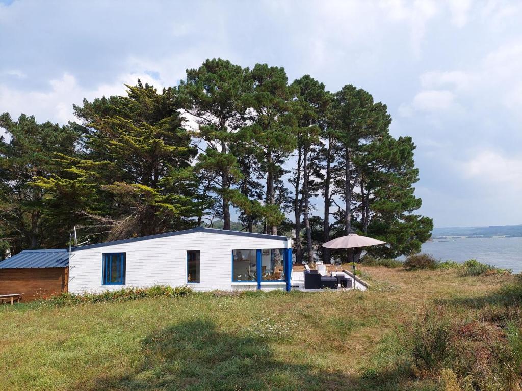 a small white house on top of a hill at Holiday home in a secluded location surrounded by the sea, Hanvec in Hanvec