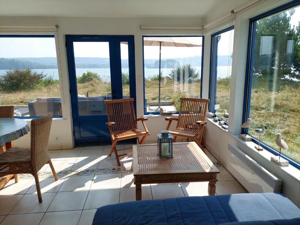 a room with two chairs and a table and windows at Holiday home in a secluded location surrounded by the sea, Hanvec in Hanvec