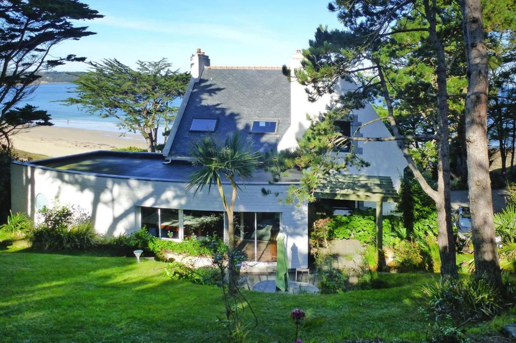 une maison blanche avec un toit bleu et une cour dans l'établissement Cottage in Locquirec with Beach Access, à Locquirec