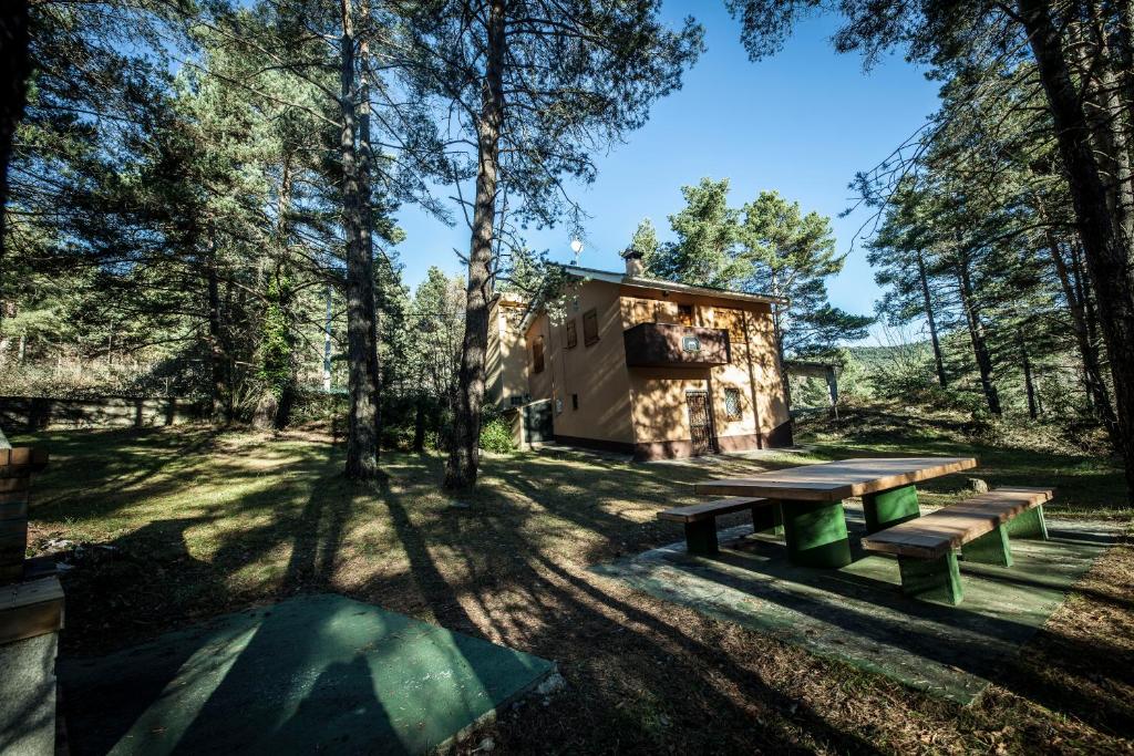 una cabaña en el bosque con bancos y árboles en Casa Espinalbet, en Castellar del Riu