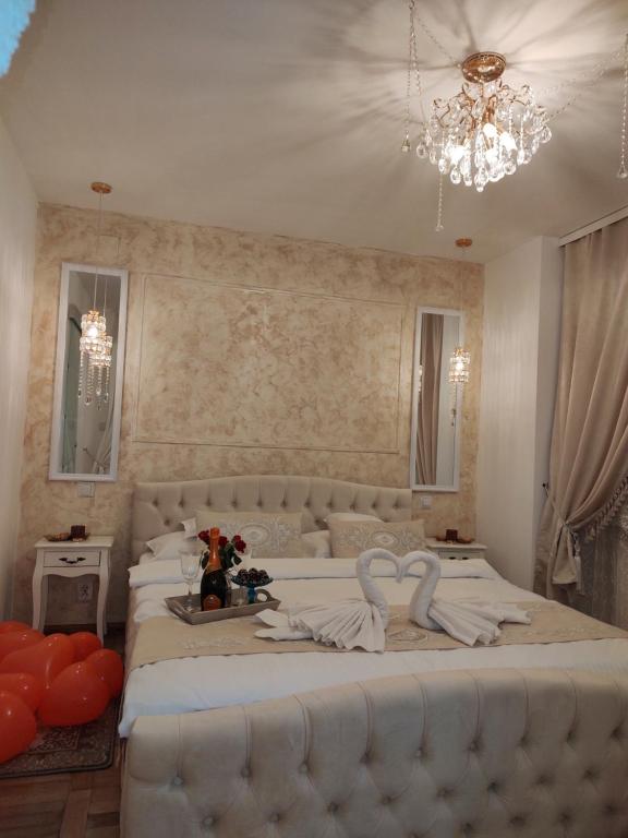 a bedroom with a large white bed with a chandelier at Penthouse Luxury in Reşiţa
