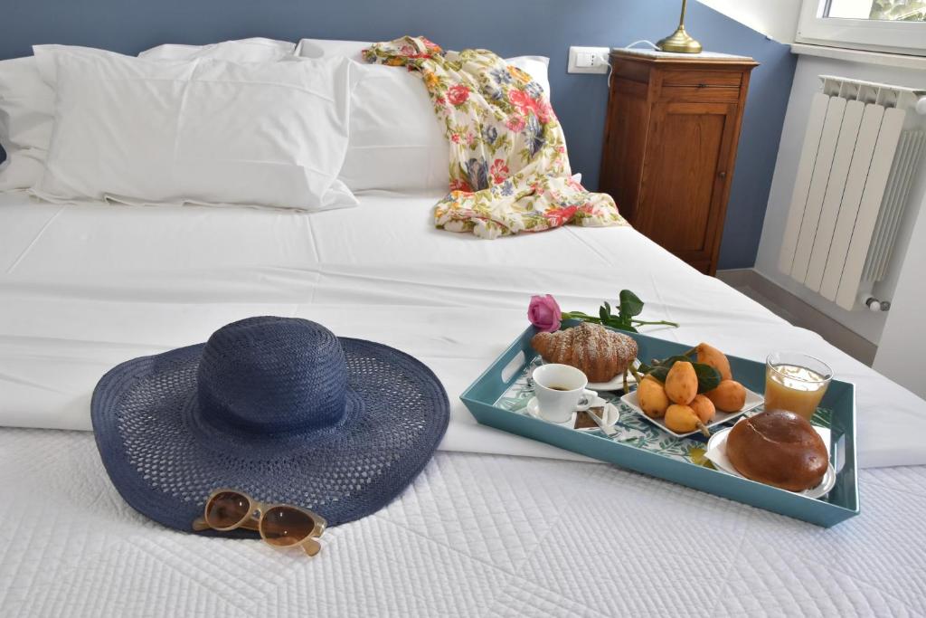 - un chapeau et un plateau de nourriture sur le lit dans l'établissement Taormina Apartments "casa di Anna", à Taormine