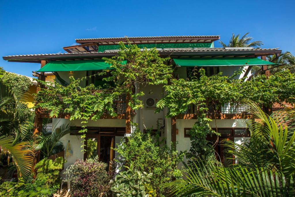 a building with trees in front of it at Casa Verde Apart - Aptos e Casa Residencial in Praia do Forte
