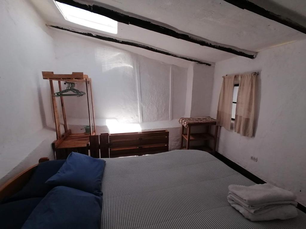 een kleine slaapkamer met een bed en een raam bij Asiriq Wasi Guest House in Cuzco