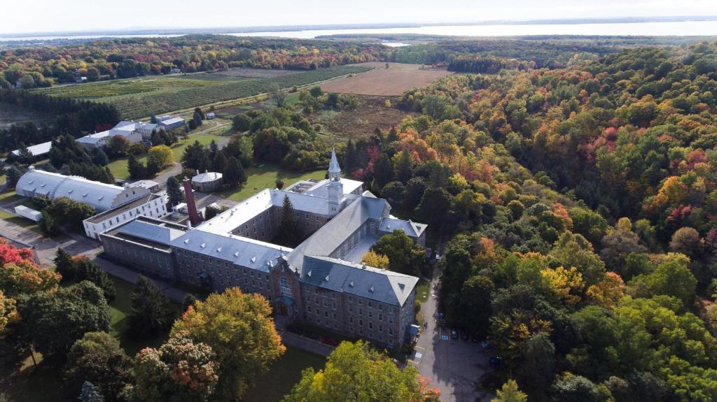 een luchtzicht op een gebouw midden in een bos bij Auberge de l'Abbaye d'Oka in Oka