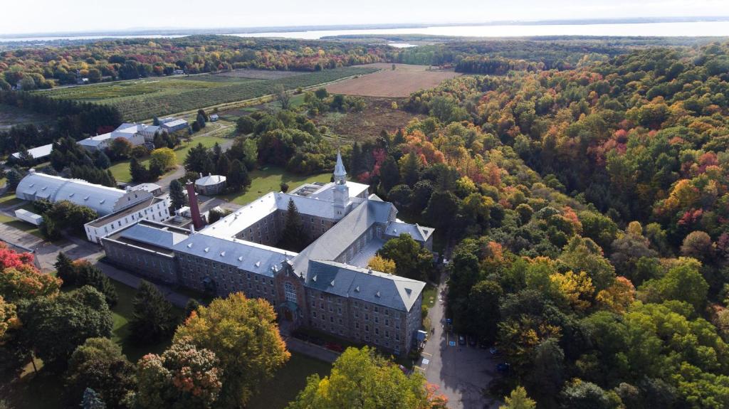 an aerial view of a building in the middle of a forest at Auberge de l'Abbaye d'Oka in Oka