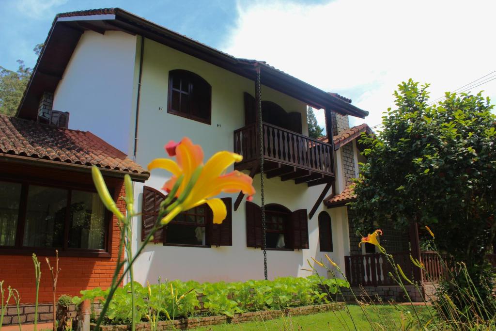 a house with a flower in front of it at Casa Incrível em Nova Friburgo - Espaço Humedica in Nova Friburgo