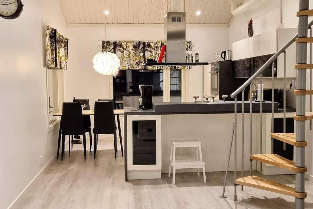 uma cozinha com um balcão, uma mesa e cadeiras em Elegantti studio lähellä Kuusamon keskustaa em Kuusamo