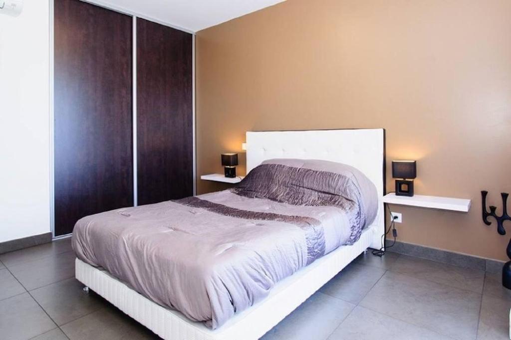 a bedroom with a large bed and two tables at T2 PORTICCIO AGOSTA PLAGE 100M DE LA PLAGE in Porticcio