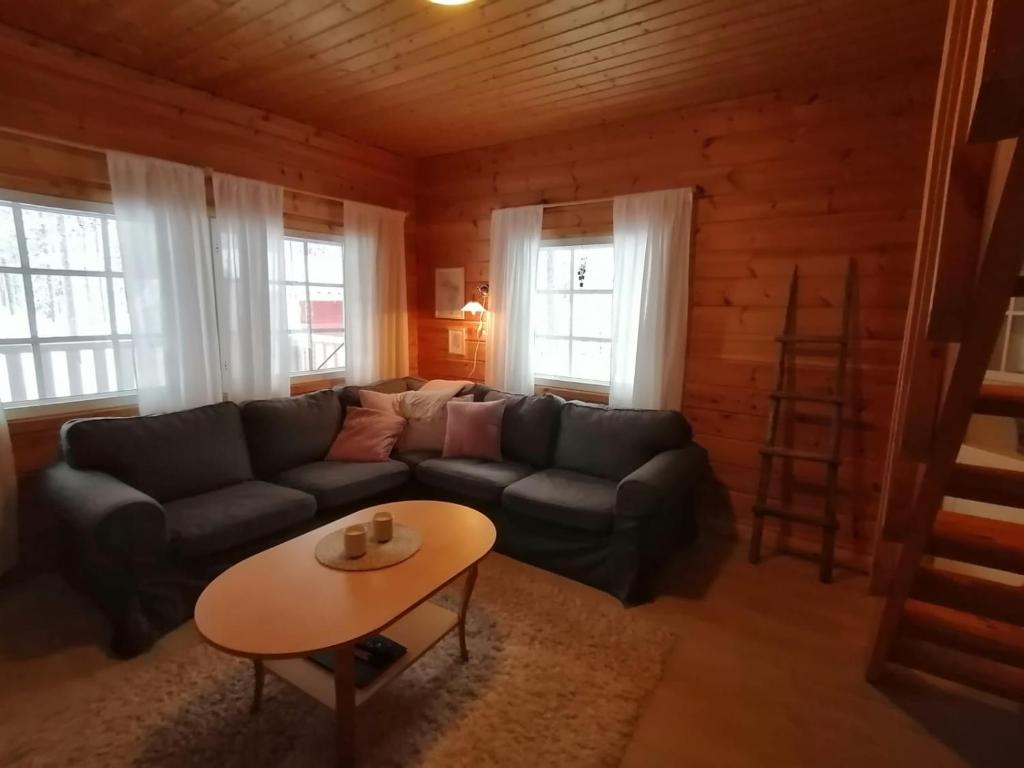 a living room with a couch and a table at Velhonkieppi in Kittilä