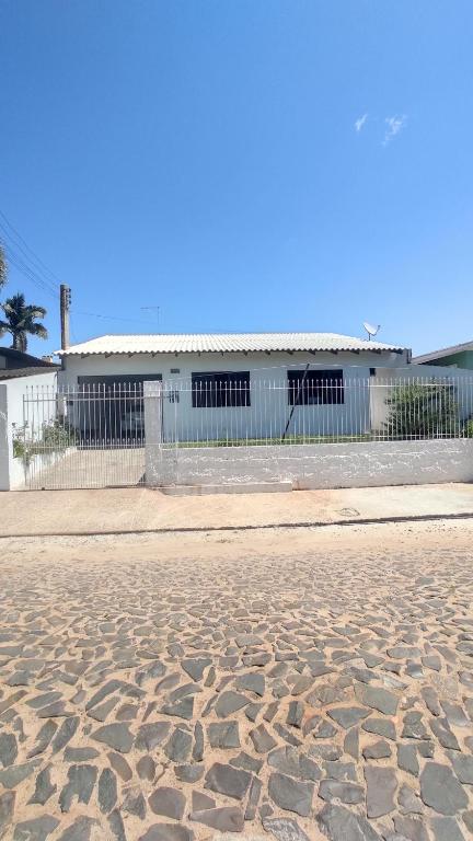 a building with a fence in front of a street at Casa na Praia, Torres RS in Torres