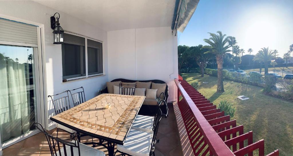 patio con mesa y sillas en el balcón en Apartamento a pie de playa, en El Portil