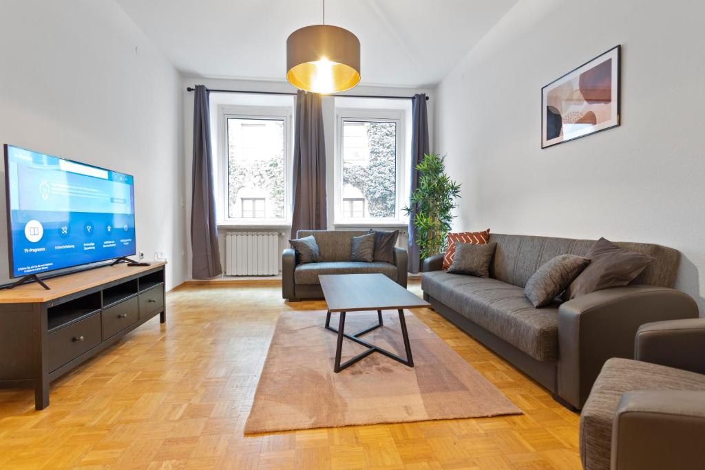 a living room with a couch and a flat screen tv at Flatista Homes - Old Town in Munich