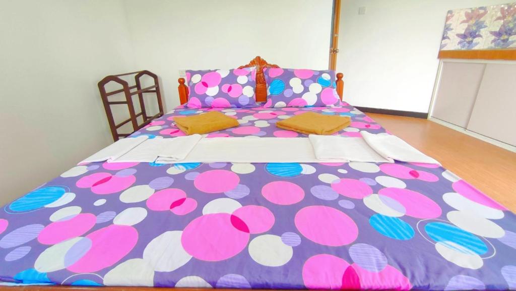 Una cama grande con una manta de lunares. en Villa Dragon House en Busse
