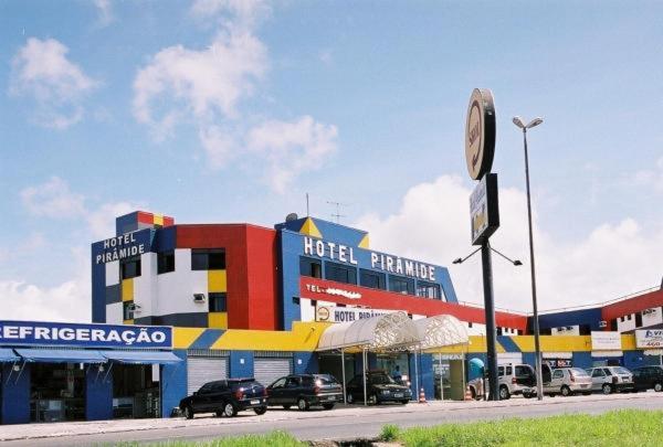 ein Hotelparkplatz mit vor einem Gebäude geparkt in der Unterkunft Hotel Piramide - Iguatemi in Salvador