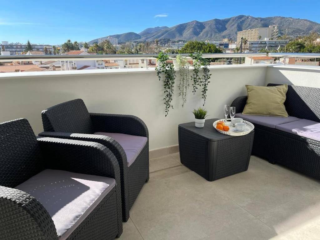 a patio with two chairs and a table on a balcony at Holidays2Torremolinos Alamos 3 bedroom & terrace & pool in Torremolinos