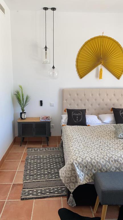 Villa 231 Boho House Estrenc - luxury family life - just 5-10min to sandy beach في سا رابيتا: غرفة نوم بسرير كبير مع اللوح الأمامي الأصفر