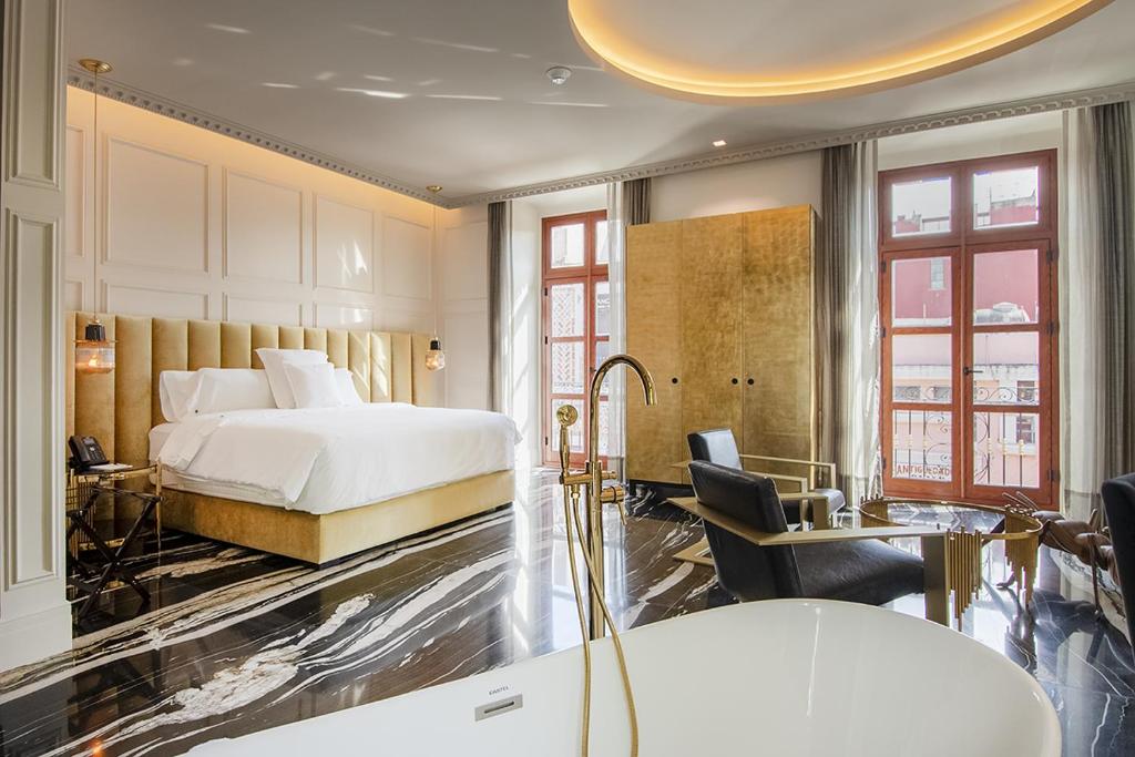 a hotel room with a bed and a desk at L Hotel Perla Boutique in Puebla