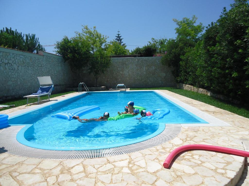 Dos personas están jugando en una piscina en Villa Dafne, en Bari