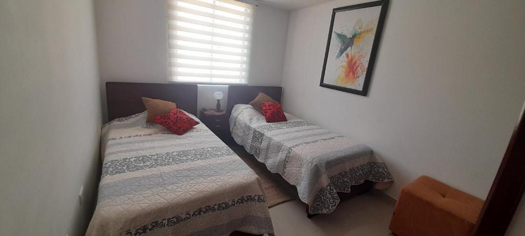 1 Schlafzimmer mit 2 Betten und einem Fenster in der Unterkunft Apartamento 402-G San Gil in San Gil