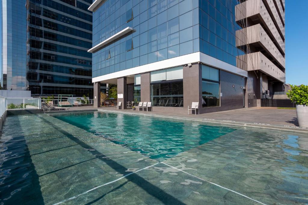 a swimming pool in front of a building at Hilton Garden Inn Praia Brava in Itajaí