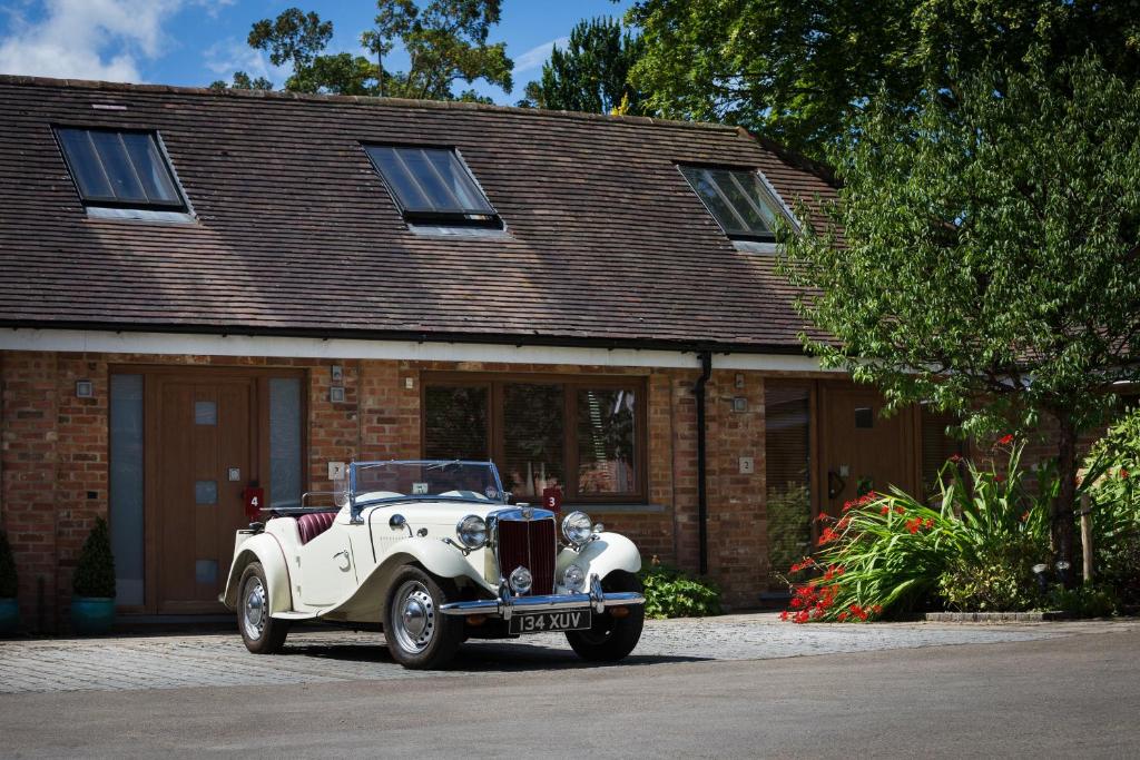 an old white car parked in front of a house at Ashbrook Lets Apartments in Blewbury