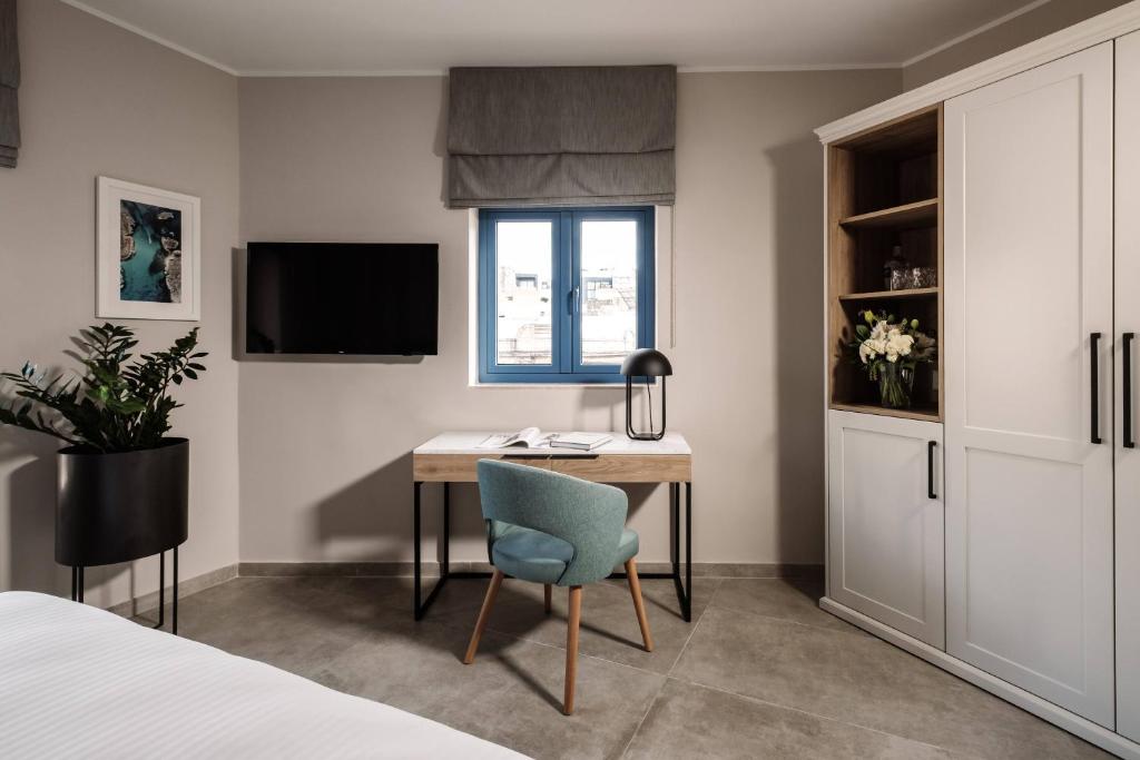 a bedroom with a desk and a bed and a window at Amery House in Sliema