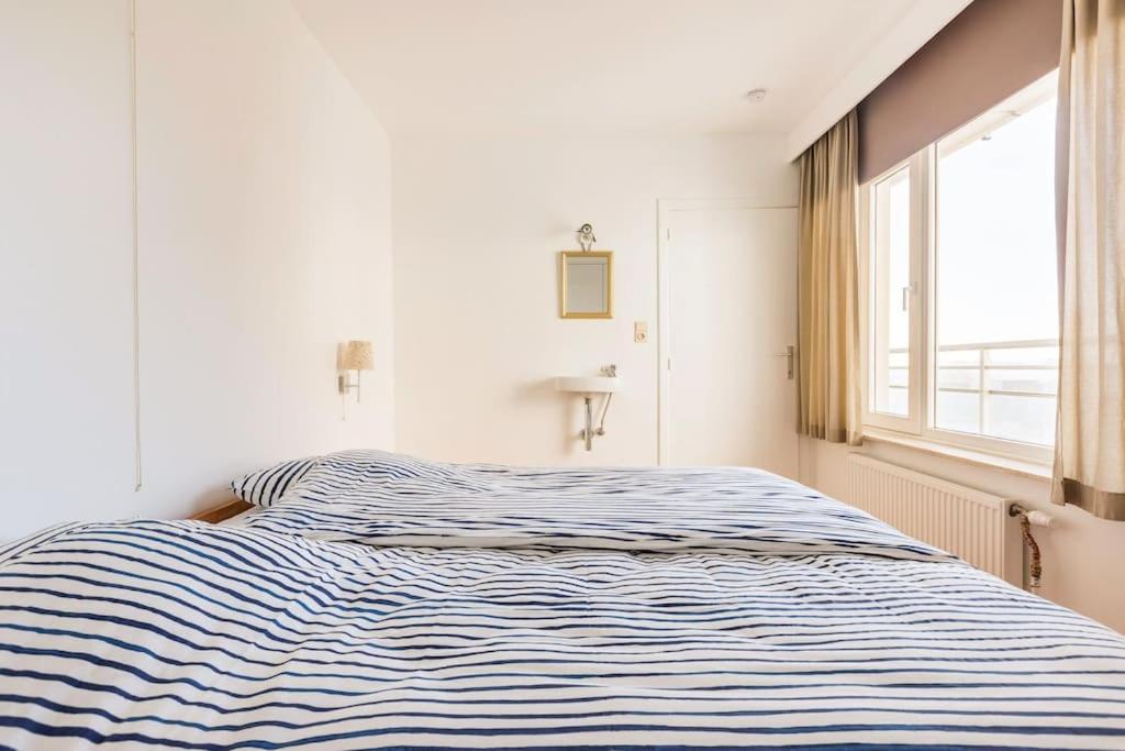 Postel nebo postele na pokoji v ubytování Gezellig appartement aan Oostduinkerkse strand