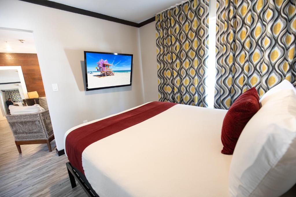 a hotel room with a bed and a television at Metropole Suites South Beach in Miami Beach