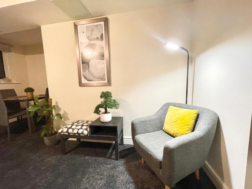 a living room with a chair and a table at Ashford Cosy 2 Bed Apartments in central location with parking, great location for contractors in Ashford