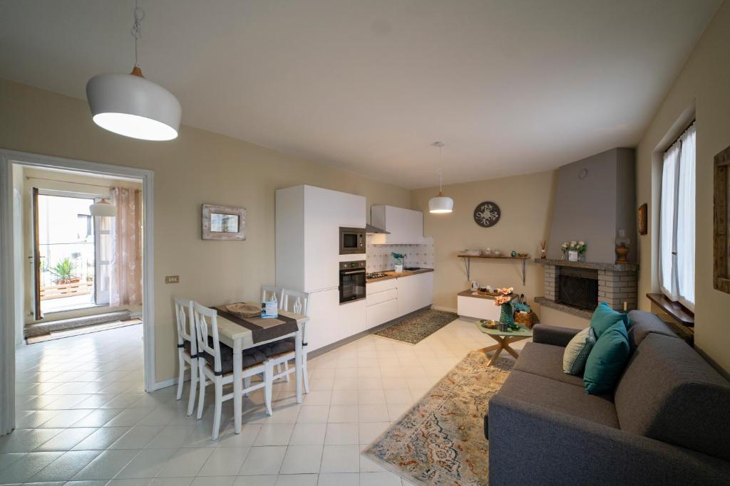 ein Wohnzimmer und eine Küche mit einem Sofa und einem Tisch in der Unterkunft SILTER - LA CASA NEL BORGO in Marone