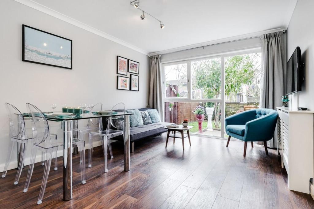 a living room with a table and a blue chair at Lovely 2 Bedroom Apartment Near South Bank in London