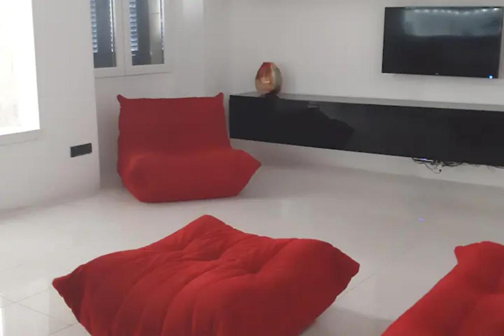 a living room with a red couch and a tv at Nr65 Valletta Portview Apartment in Valletta
