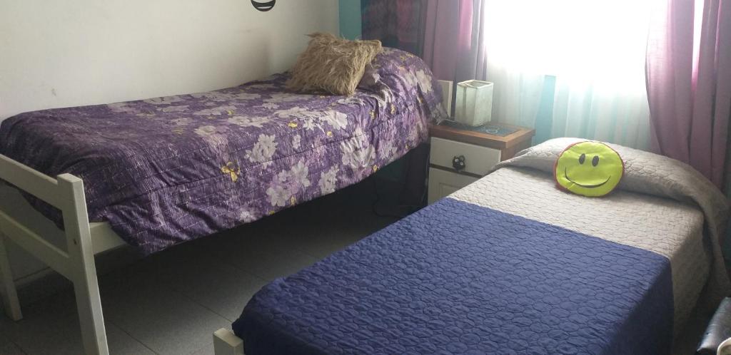 een slaapkamer met 2 bedden met paarse en witte lakens bij Habitación en casa in Bariloche