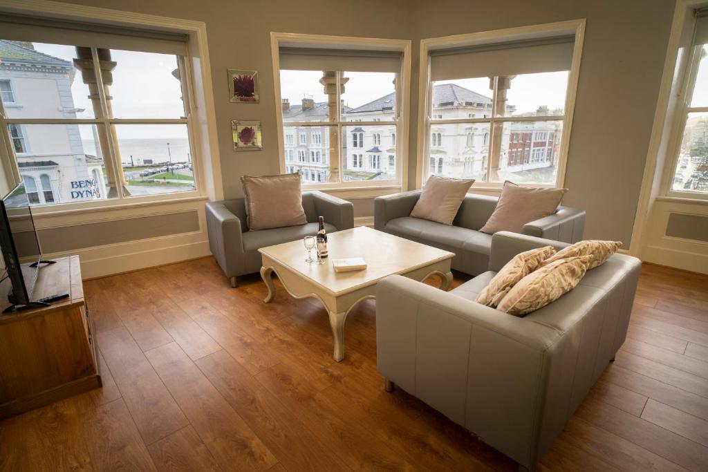 a living room with a couch and a coffee table at Cornerhouse Apartments Llandudno in Llandudno