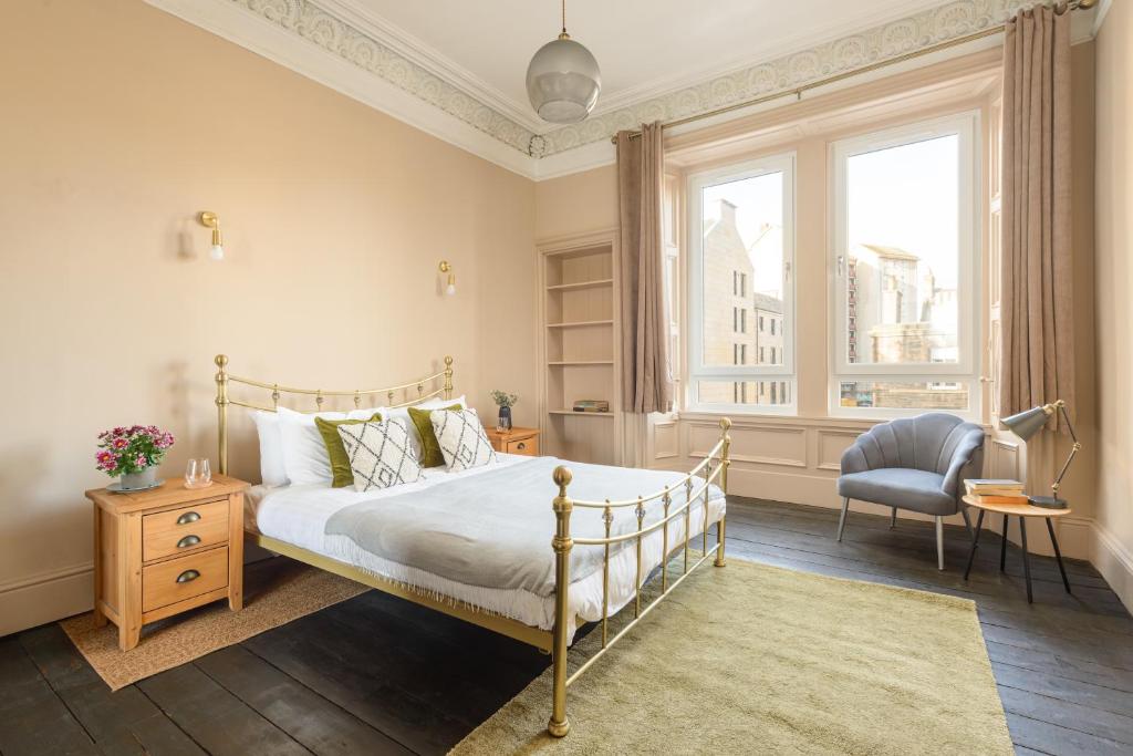 - une chambre avec un lit, une chaise et une fenêtre dans l'établissement Spacious 2BR Leith Apartment, à Édimbourg