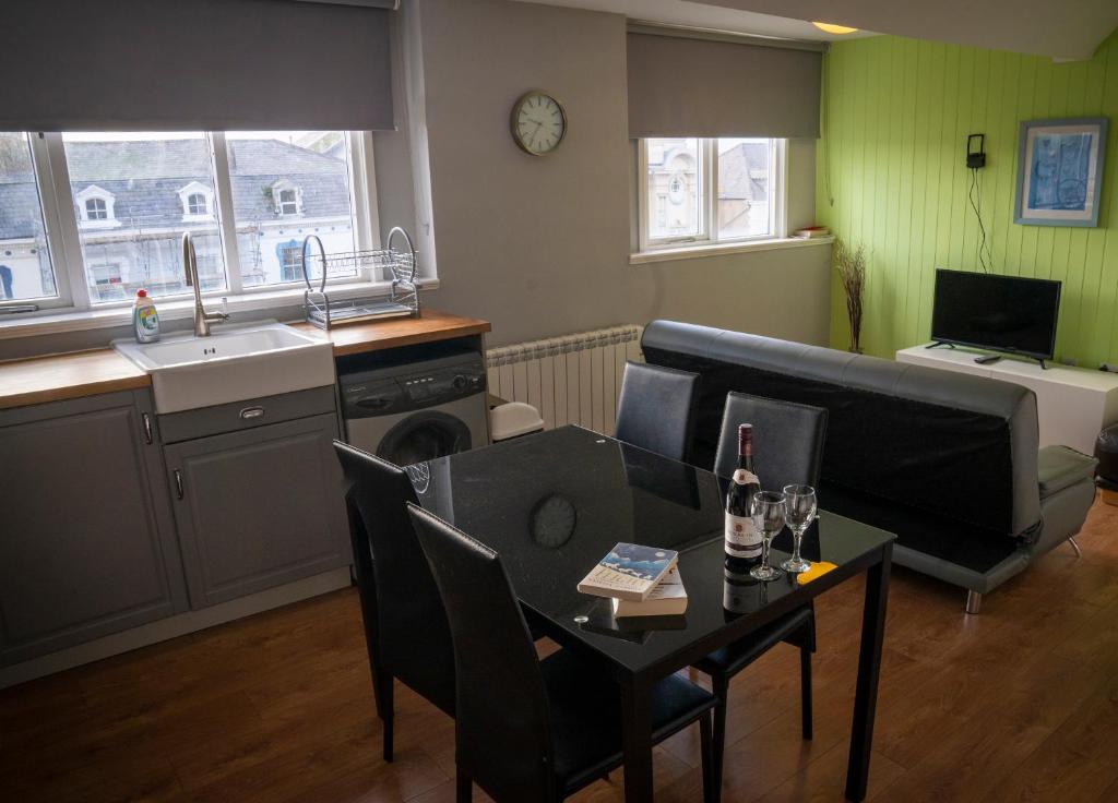a living room with a table and a kitchen at Apartment 4, Cornerhouse Apartments in Llandudno