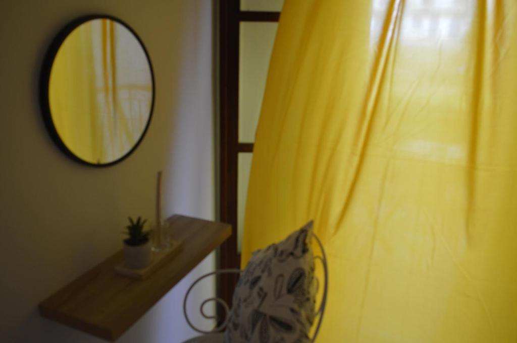 a room with a mirror and a curtain and a chair at Pansion Katerina in Skiathos
