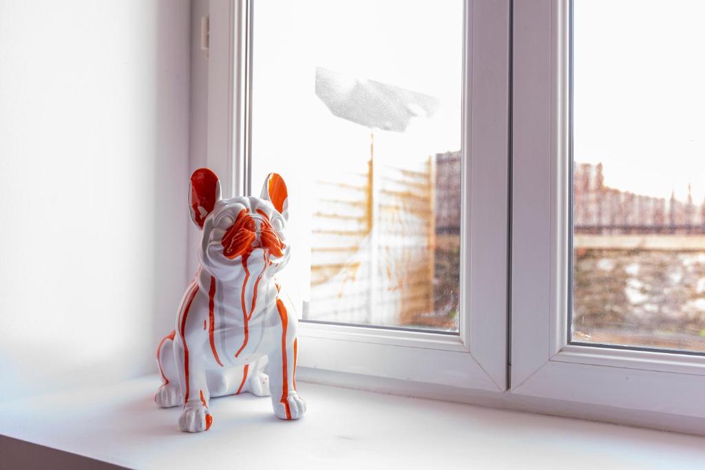 a small toy dog sitting on a window sill at Jolie maison proche centre-ville et plages in Granville